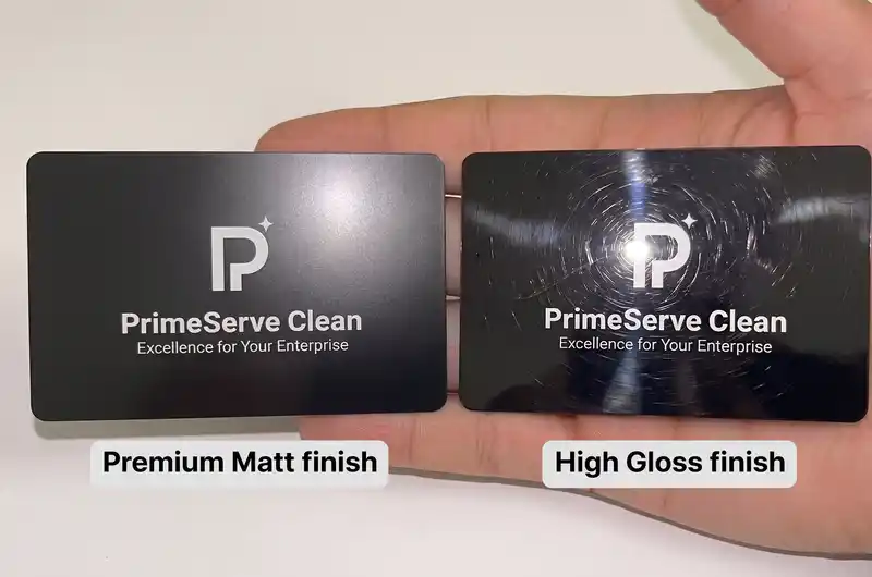 two black plastic cards with the same white logo side by side, the Premium Matt card looking clean and the High Gloss card showing swirl scratches in the light