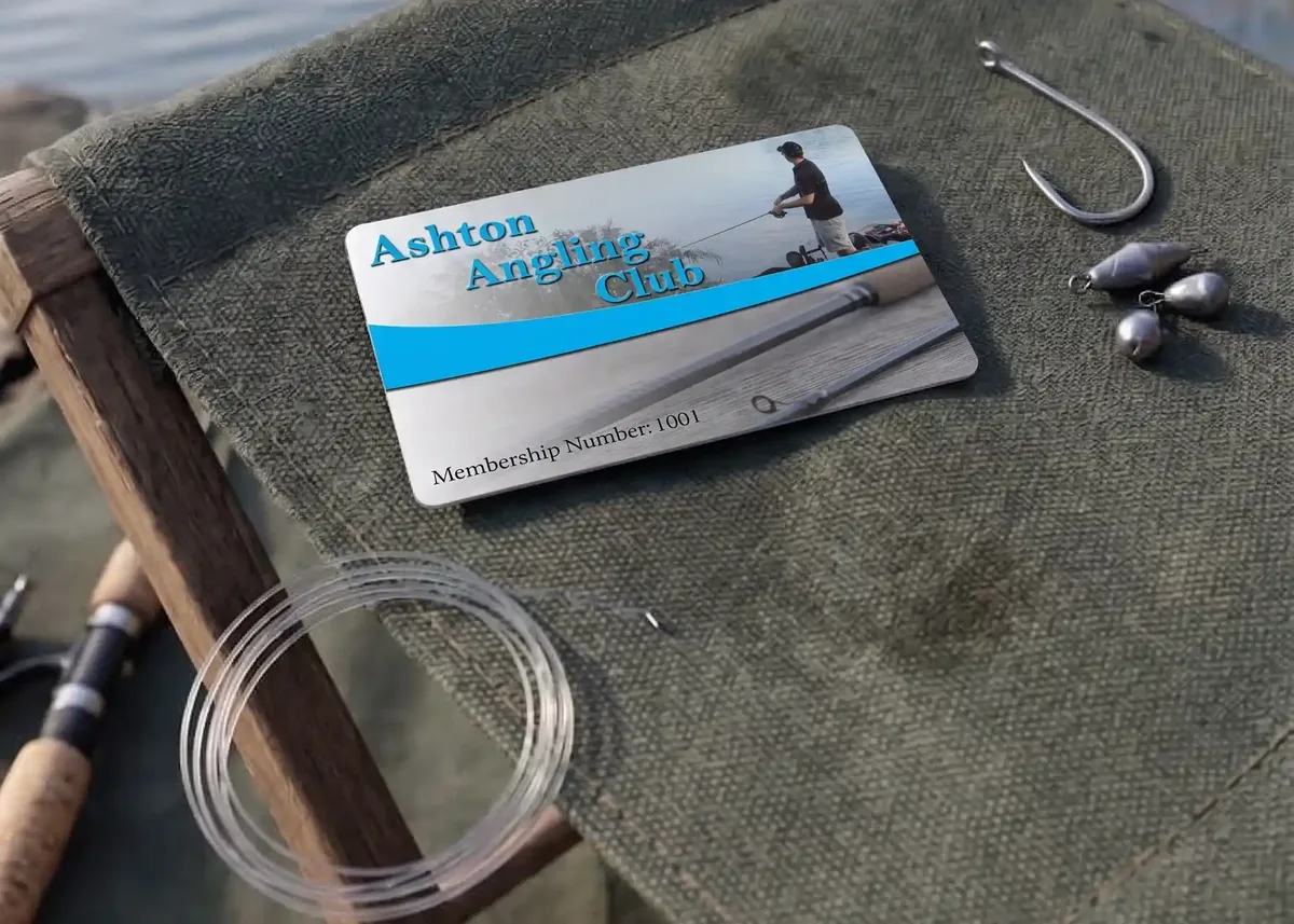 Ashton Angling Club membership card with hook and weights on a fishing chair