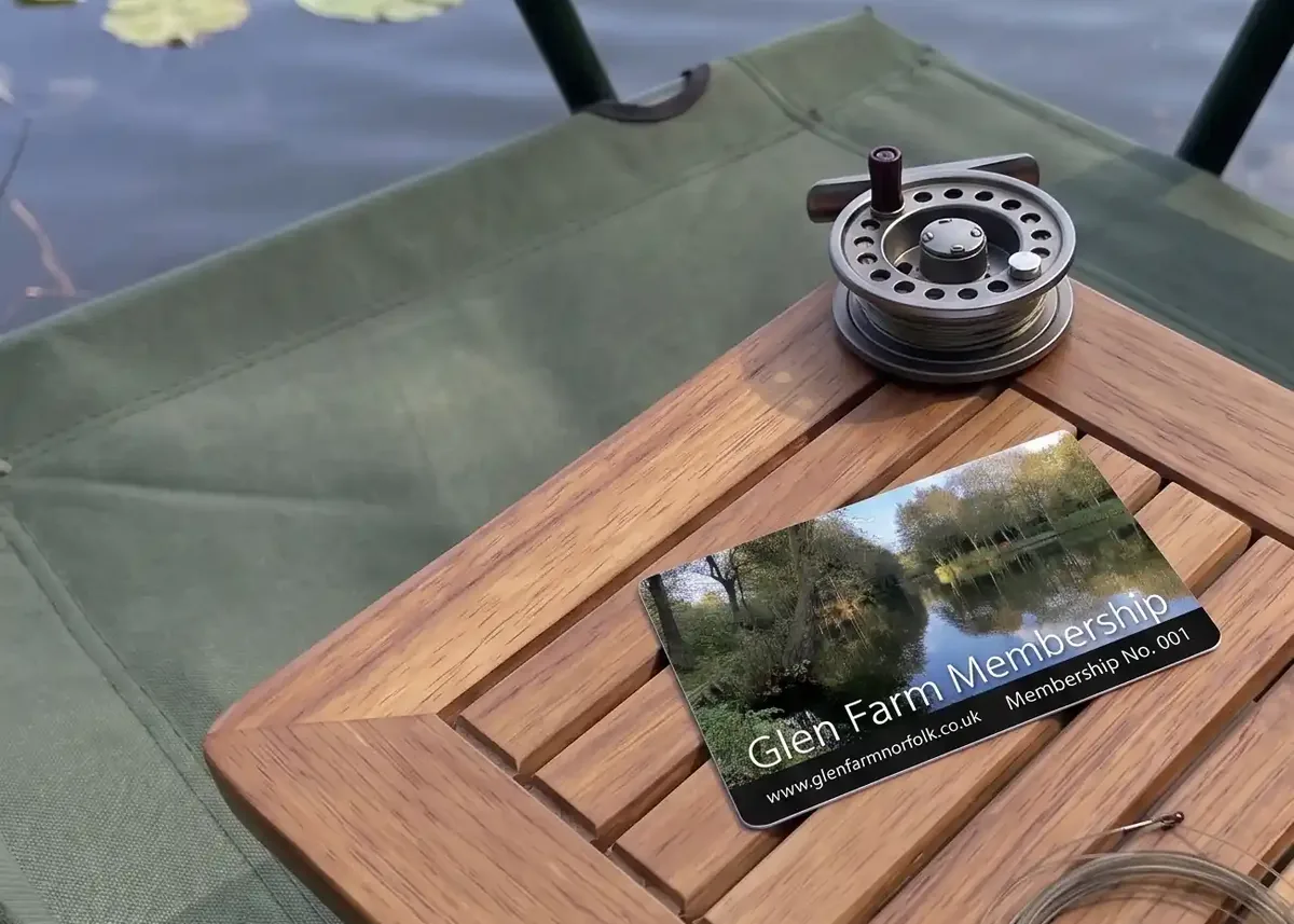 Glen Farm membership card on a tackle table beside a fishing reel