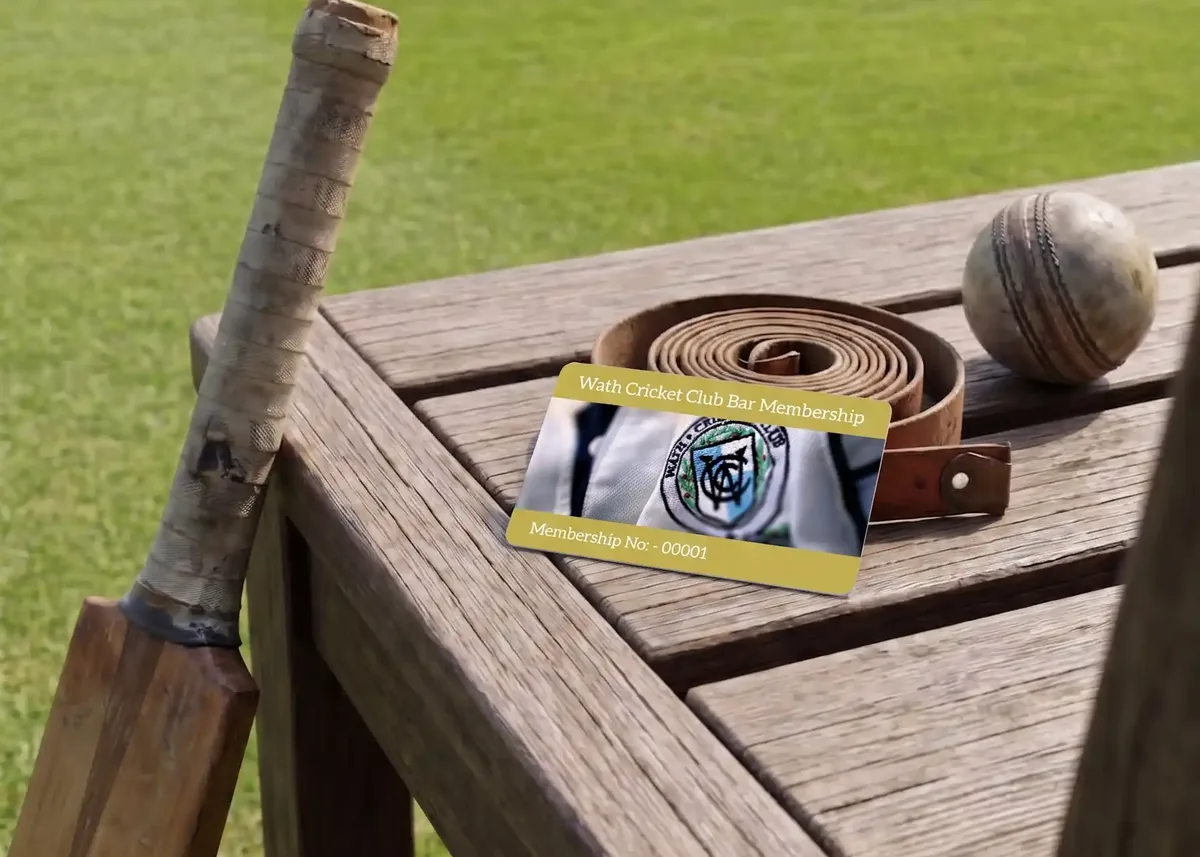 Cricket club membership card on a wooden bench by the pitch