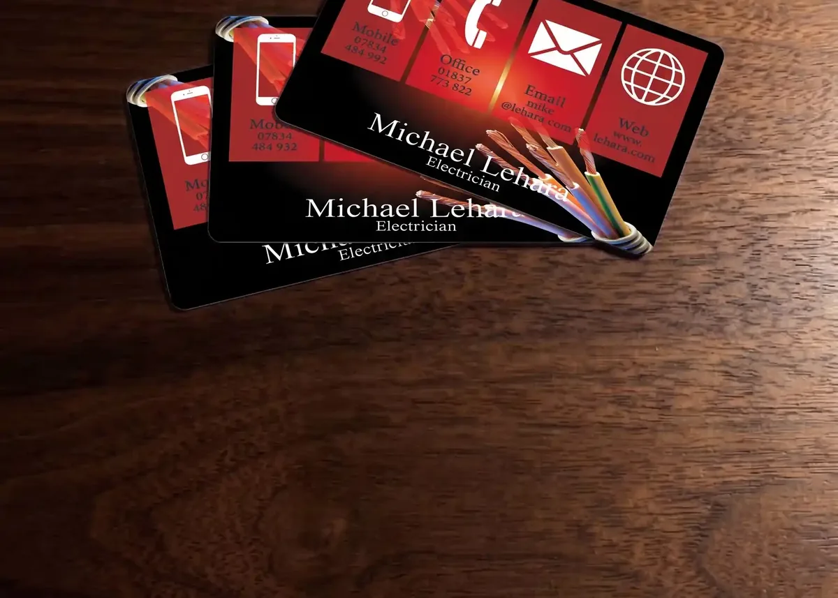 Electrician plastic business cards on a wooden desk