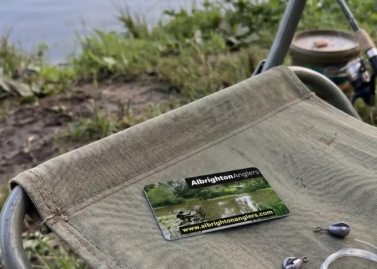 Albrighton Anglers membership card on a fishing chair by the water