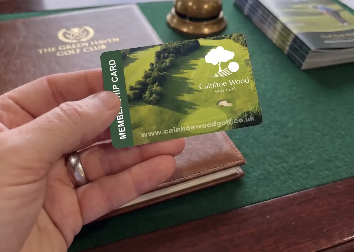 Golf club membership card held at a clubhouse desk