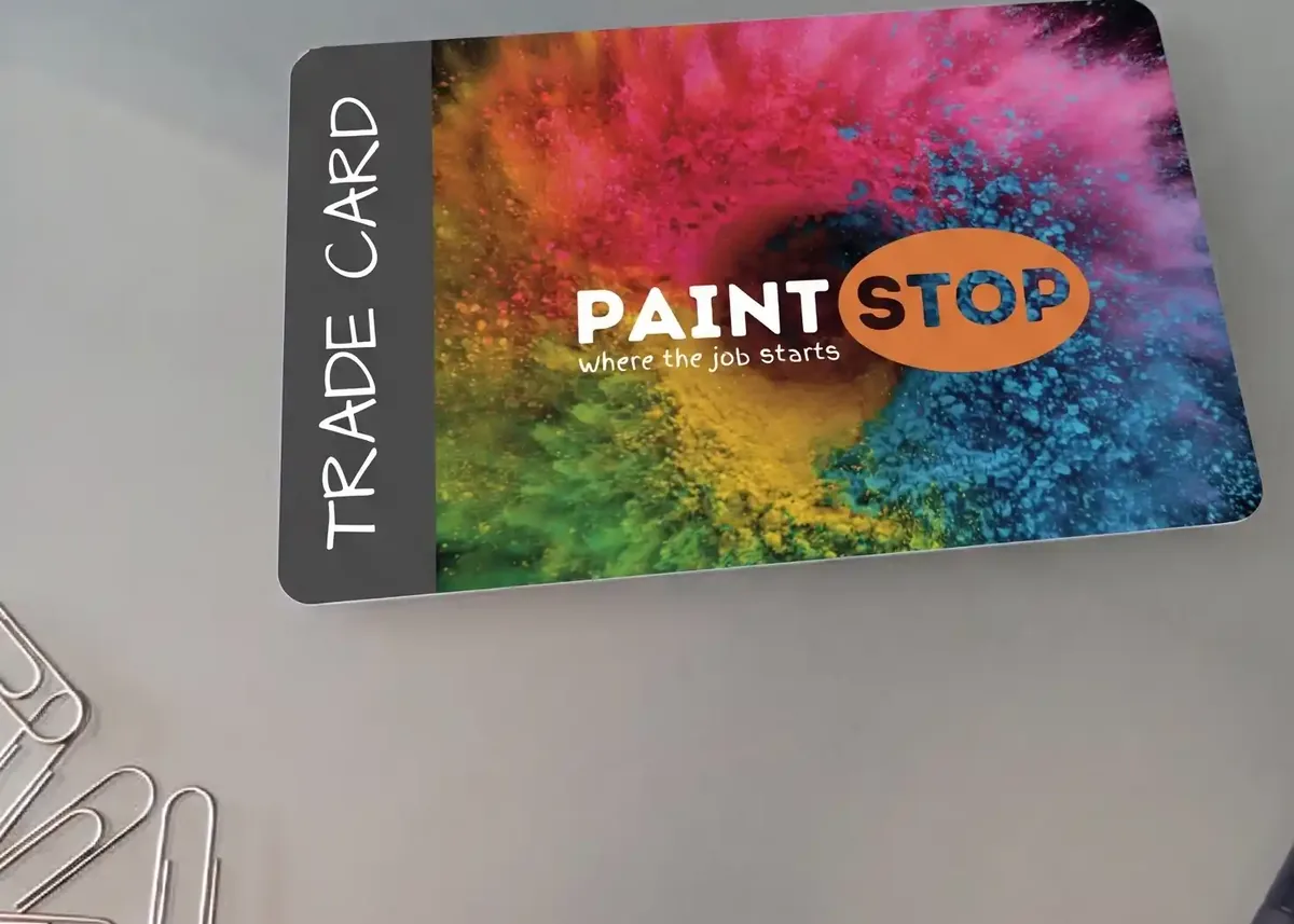 Paint Stop plastic trade card on a desk with paper clips