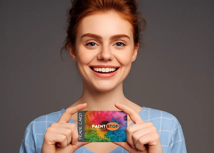 a woman holding up a full colour plastic trade card printed with bright paint colours