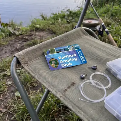 Earlford Angling Club membership card on a fishing chair with tackle