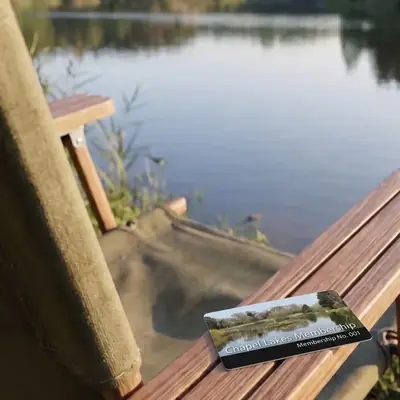 Glen Farm membership card on the arm of a lakeside chair