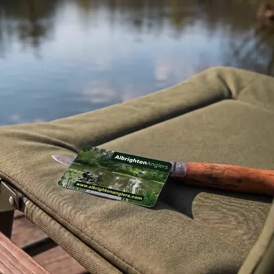 Albrighton Anglers membership card on a fishing chair by the lake