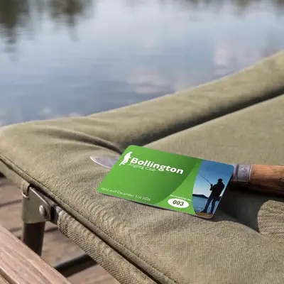 Bollington angling club membership card on a fishing bedchair by the lake