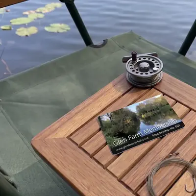Glen Farm membership card on a tackle table beside a fishing reel