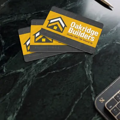 Oakridge Builders plastic business cards on a marble surface