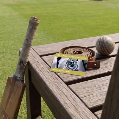 Cricket club membership card on a wooden bench by the pitch
