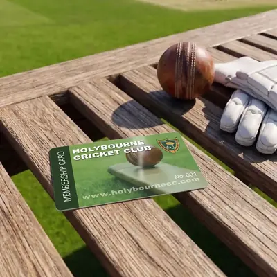 Holybourne Cricket Club membership card on a bench beside batting gloves