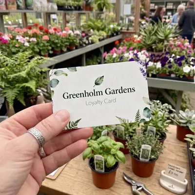 Greenholm Gardens loyalty card held in a garden centre