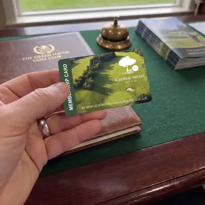 Golf club membership card held at a clubhouse desk