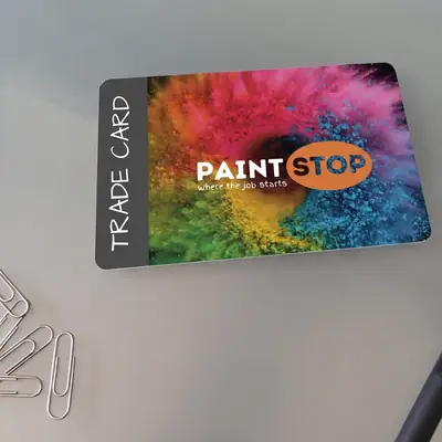 Paint Stop plastic trade card on a desk with paper clips